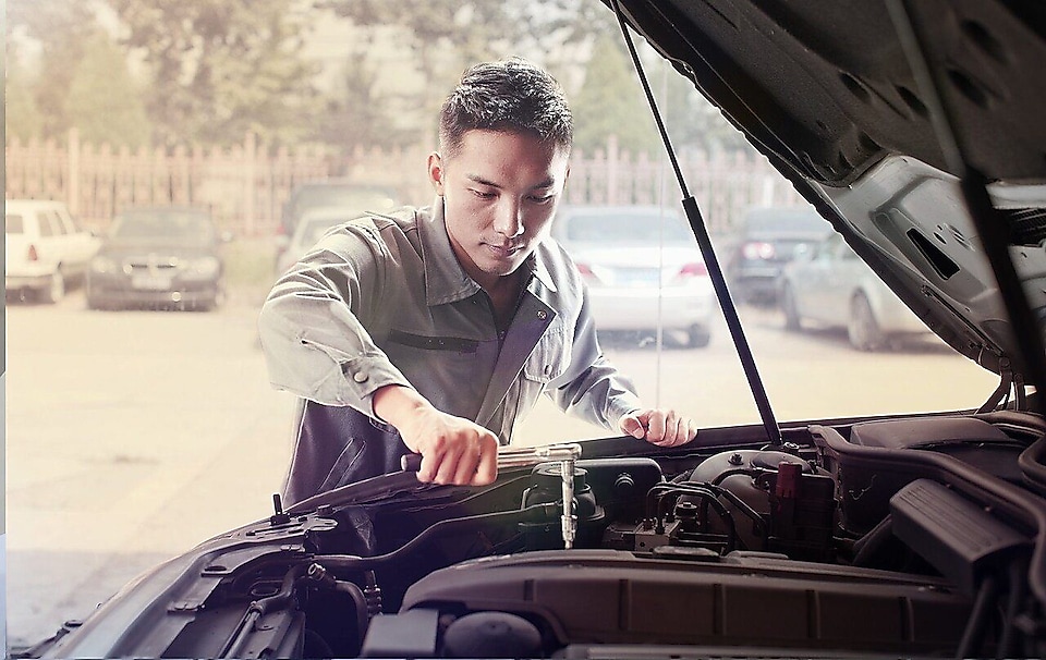 Mekaanikko korjaamassa autoa.